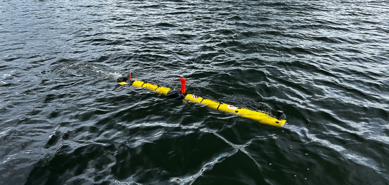 An integrated AUV underway during field trials, now a live two-way acoustic control plane rather than a one-way data carrier.